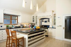 a kitchen with white cabinets and a black counter top at Inḃear Scéine in Kenmare