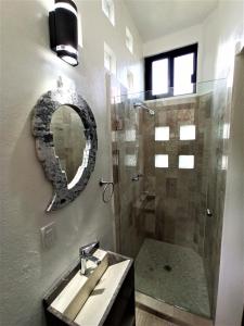 a bathroom with a sink and a shower with a mirror at CASA ANTARES in Tepoztlán