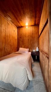 a bedroom with a bed in a wooden wall at Chakra Tavern in Bedugul