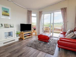 uma sala de estar com uma televisão, um sofá e uma lareira em Chi Prenn Byhan em Tintagel