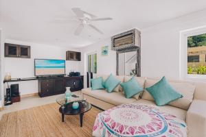 a living room with a couch and a flat screen tv at Samui Art Villa in Bophut