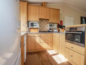 uma cozinha com armários de madeira e electrodomésticos de aço inoxidável em Chi Prenn Byhan em Tintagel