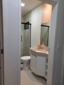 ein Badezimmer mit einem WC, einem Waschbecken und einem Spiegel in der Unterkunft Flats Tavares Araujo in Garanhuns