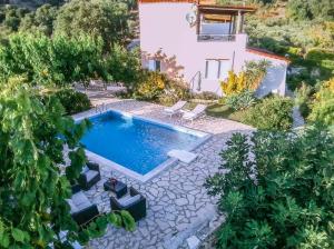 an image of a swimming pool in front of a house at villa Nefeli in Lambiní