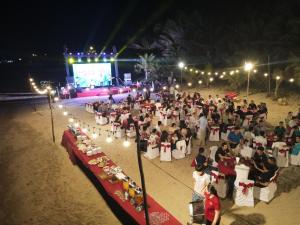 un grande gruppo di persone sedute su una spiaggia di notte di Suoi Hong Resort a Mui Ne Altre 57 foto