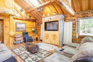 a log cabin living room with a tv and a couch at Indian AK 25 min to Anchorage & 25 min to Girdwood in Anchorage