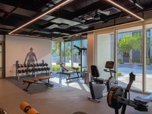 a gym with a lot of exercise equipment and windows at Modern Urban 3 bedroom apartment Dubai Creek Harbour in Dubai