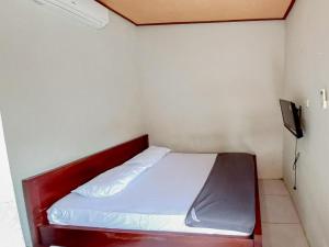 een kleine slaapkamer met een bed met een rood frame bij Hotel Gerung 2 near Luwes Mall Nganjuk Mitra RedDoorz in Nganjuk