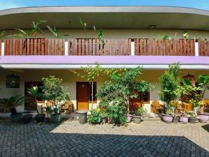 Ein Gebäude mit einem Haufen Topfpflanzen davor. in der Unterkunft Hotel Gerung 2 near Luwes Mall Nganjuk Mitra RedDoorz in Nganjuk