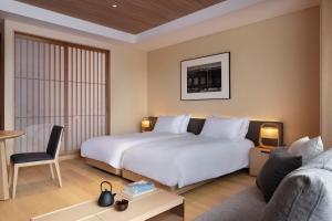 Habitación de hotel con cama y sofá en Setsu Niseko, en Niseko