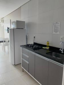 a white kitchen with a refrigerator and a sink at Residencial Florida in Bombinhas