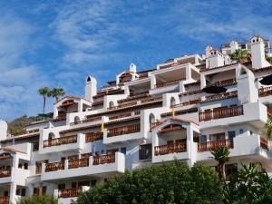 ein weißes Apartmenthaus mit Bäumen davor in der Unterkunft Modern Hamilton Cove Villa w/golf cart in Avalon