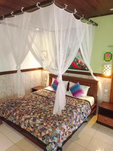 1 dormitorio con 1 cama con dosel en Putu Guest House Pemuteran en Pemuteran