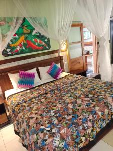 佩母得蘭的住宿－佩母得蘭譜圖旅館，一间卧室配有一张带五颜六色被子的床