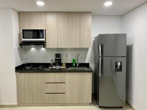 サバネタにあるPiso26 Beautifull Apartment and Parkingのキッチン(ステンレス製の冷蔵庫、電子レンジ付)