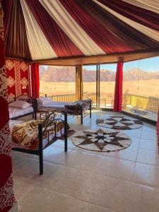 1 dormitorio con 2 camas en una habitación con vistas en Bedouin Holidays Camp and Jeep Tours, en Wadi Rum