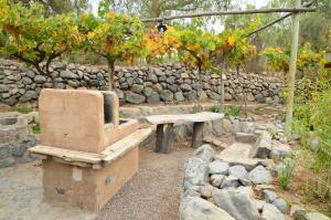 uma parede de pedra com um banco e uma mesa de pedra em Cabañas AHOPIEDRA em Vicuña