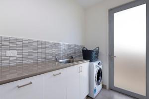 eine Küche mit einer Spüle und einer Waschmaschine in der Unterkunft 103 Beach Street in Port Fairy