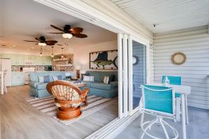 a screened in porch with a living room and kitchen at Beach on the Rocks in Clearwater Beach