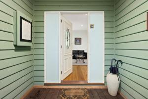an open door in a room with green siding at Paddys Creek Retreat in Upwey