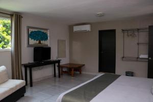 sypialnia z łóżkiem, biurkiem i kanapą w obiekcie Hotel Garden Suites Tonalá w mieście Tonalá