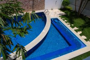 niebieski basen w ogrodzie z roślinami w obiekcie Hotel Garden Suites Tonalá w mieście Tonalá