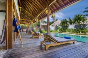 a wooden deck with a swimming pool and a villa at 3 BDRMS private VILLA - Bingin Beach in Uluwatu