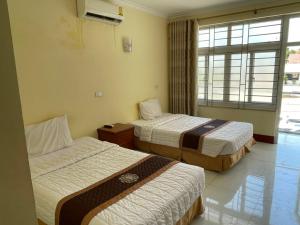 um quarto de hotel com duas camas e uma janela em Mekong Hotel em Ban Nabông