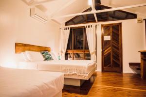 um quarto de hotel com duas camas e uma porta em Daintree Wilderness Lodge em Daintree