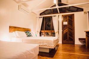 a hotel room with two beds and a door at Daintree Wilderness Lodge in Daintree