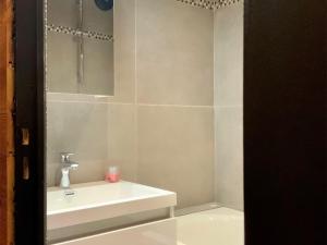een witte badkamer met een wastafel en een spiegel bij Appartement Val Thorens, 3 pièces, 4 personnes - FR-1-637-44 in Val Thorens