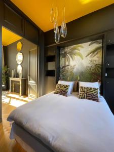 The Suites في بلايي: غرفة نوم مع سرير أبيض كبير مع لوحة على الحائط