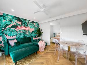 ein Wohnzimmer mit einem grünen Sofa und einem Tisch in der Unterkunft Lusso Retreats in Moffatdale