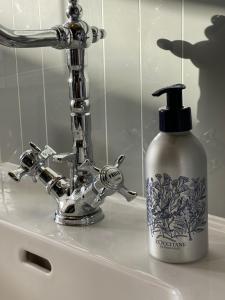 a bottle of soap sitting next to a bathroom sink at The Suites in Blaye +33 photos