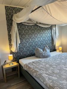 Timeout Westerwald في Ellar: غرفة نوم بسرير مظلة وطاولة جانبية