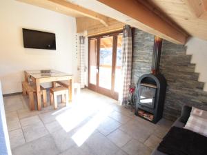 a living room with a wood stove and a table at Appartement Les Carroz d'Arâches, 2 pièces, 4 personnes - FR-1-572-259 in Arâches-la-Frasse