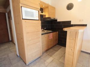 uma cozinha com armários de madeira e um lavatório em Appartement Les Carroz d'Arâches, 2 pièces, 4 personnes - FR-1-572-259 em Arâches-la-Frasse