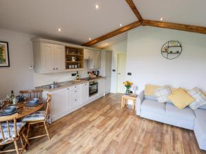 a kitchen and living room with a couch and a table at Celyn in Ruthin
