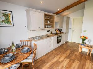 a kitchen with a wooden table and a dining room at Celyn in Ruthin