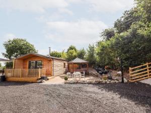 Cabaña de madera con porche y valla en Celyn, en Ruthin