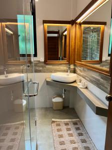 a bathroom with two sinks and a glass shower at Hidden relaxation at Kings residence in Kandy