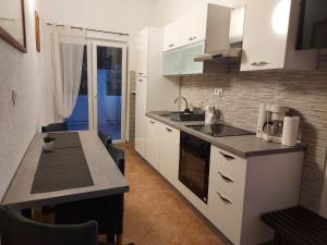 a kitchen with white cabinets and a counter top at Apartments Davorka - sea view in Kampor