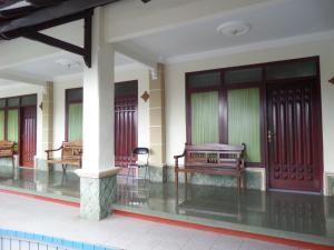 a building with benches in the middle of a courtyard at Sukapura Permai Hotel in Lambangkuning