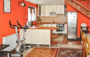 a kitchen with orange walls and a treadmill at Amazing home in Ruciane-Nida with 3 Bedrooms, Sauna and WiFi in Ukta