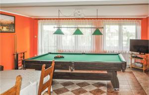 UktaにあるGorgeous Home In Ruciane-nida With Saunaのオレンジの壁のリビングルーム(ビリヤード台付)
