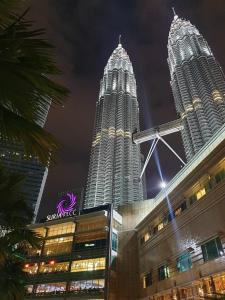 two large skyscrapers in a city at night at AllOfUs GuestRoom in Kuala Lumpur