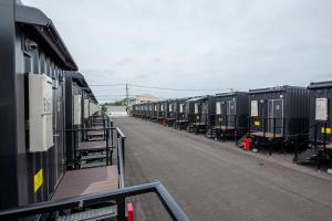 a row of train cars parked next to a street at HOTEL R9 The Yard Uki in Uki