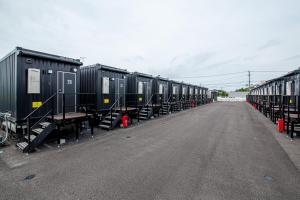 een rij treinwagons geparkeerd op een parkeerplaats bij HOTEL R9 The Yard Uki in Uki