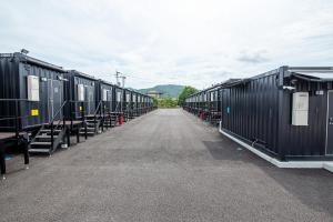 Une rangée de wagons alignés sur une route dans l'établissement HOTEL R9 The Yard Uki, à Uki