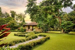 een huis met een tuin met een stenen pad dat naar het huis leidt bij Green Mansions Jungle Resort in Sauraha